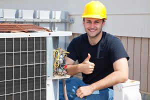 HVAC technician working on air conditioning compressor