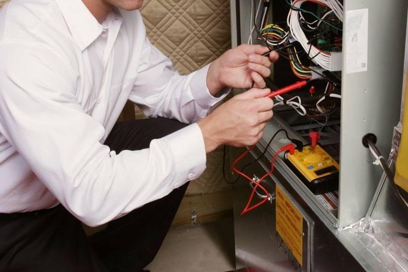 hvac technician repairing furnace