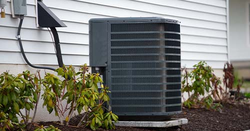 Image: a condenser by the side of the house. HELP provides the best Brandt Air Conditioner Repair.