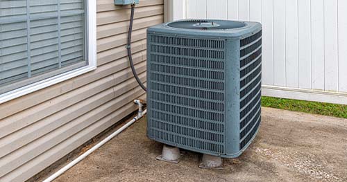 Image: an AC condenser in a back yard. Never underestimate the necessity of an AC tune-up.