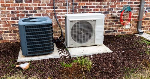Image: a condenser and mini-split side by side. Looking for HVAC help, look no further than HELP for Byron Air Conditioner Services.