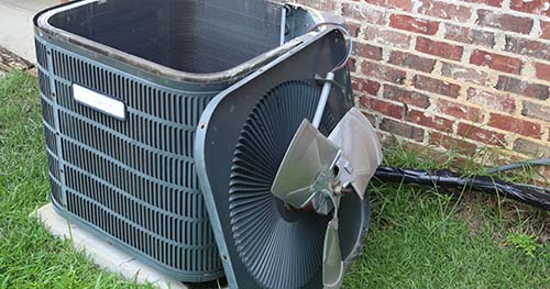 Image: a condenser with the top off while receiving service. When it comes to Carlisle air conditioning, you need to have two tune-ups per year.
