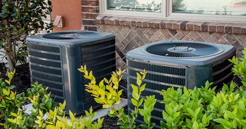 Image: two condensers side by side. For Centerville air conditioning services, HELP is the company to call.