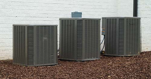 Image: three condensers of different sizes in a row next to each other. Residents looking for Corwin air conditioner repair should call the experts at HELP. 