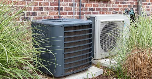 Image: a condenser and mini-split sit side by side. HELP is always on hard for Crosswick air conditioner installation and replacement.