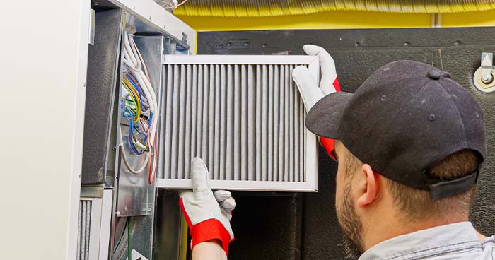 Image: An HVAC technician changing out an air filter.
