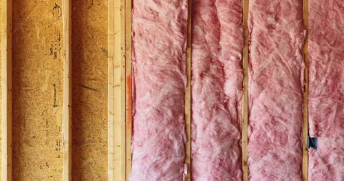 Image: batt insulation hanging on attic walls.