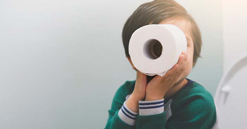 Image: a child playing with an extra soft roll of toilet paper.