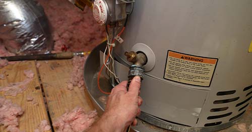 Image: a person preforming a water heater flush.