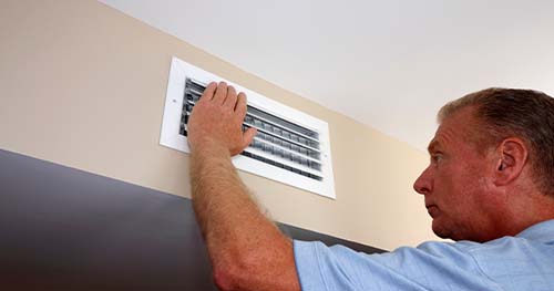 Image: a man checks his vents and wonders why there's not air coming out.