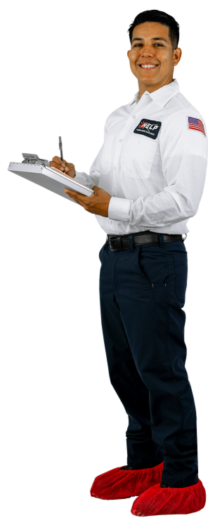 A person in a white shirt with a name tag, holding a clipboard and pen, smiles while wearing red shoe covers.